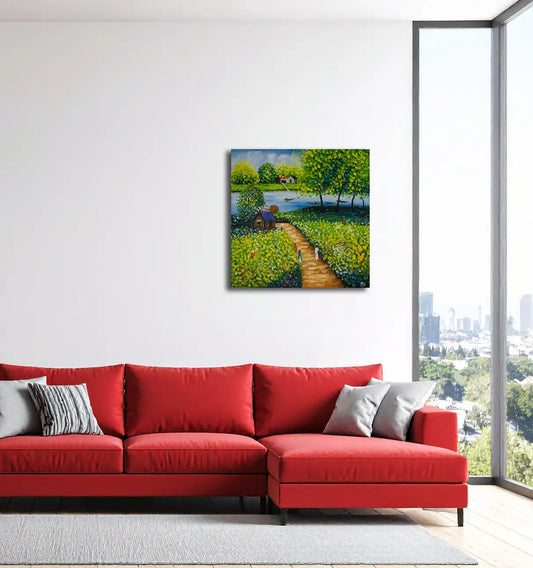 Landschaftsgemälde, grüne und gelbe Farbtone, ein Fluß mit kleinen Booten, eine kleine Hütte und Personen auf auf einem Weg, an einer hellen Wand hängend mit rotem Sofa