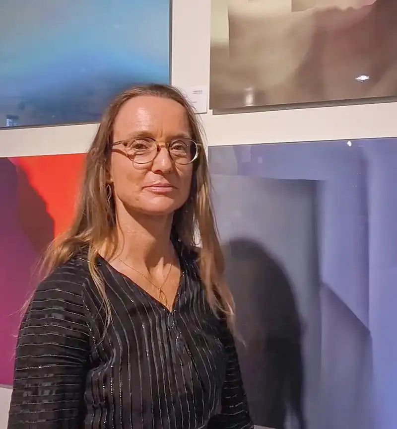 Portrait Maria Schley vor einem ihrer abstrakten Kunstwerke