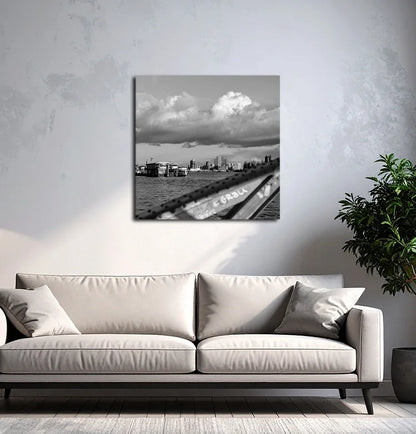 Ein schwarz Weiß Foto der Elbe mit Elbphilharmonie, Hanseatic Trade Center, Fähren und einem Brückenbogen, an einer hellen wand mit grauem Sofa