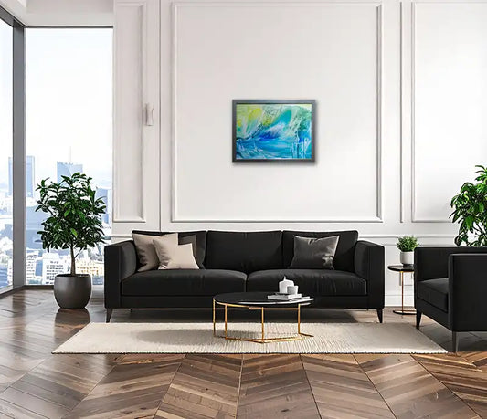 abstraktes Gemälde eines Gletschers, blau, grüne, gelbe Farbverläufe, silberfarbener Rahmen., an einer hellen Wand hängen, schwarzes Sofa vor der Wand