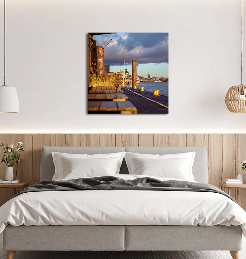 Das Farbfoto von J.P. Ehlers zeigt ein mildes Licht, die Elbe, einen Anleger, ein urbanes Fotos, an Wand hängend im Schlafzimmer