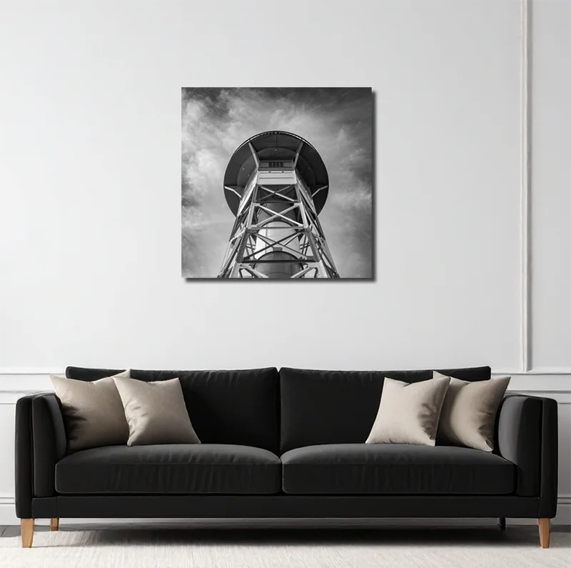 Schwarz-weiß foto eines  Leutchtturms an der Elbe, von unten gesehen, symetrischer Aufbau, an heller Wand hängend mit schwarzem Sofa